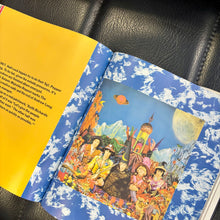 Load image into Gallery viewer, Open book with colorful illustrations on a black leather surface
