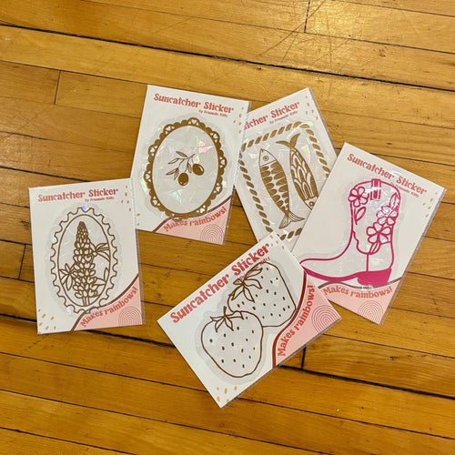 Five printed cards with illustrations on a wooden floor