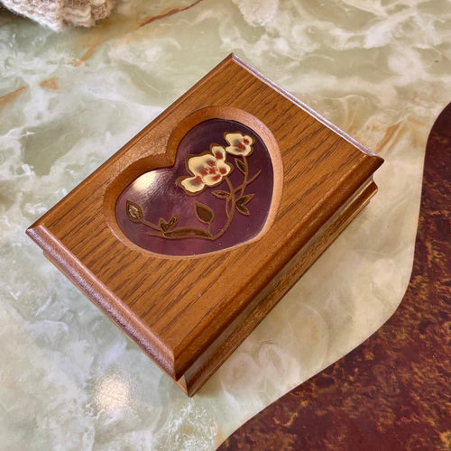 Wooden box with floral design on a marble surface